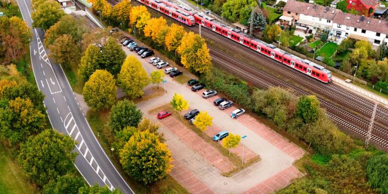 Luftaufnahme eines Parkplatzes an einem Bahnhof